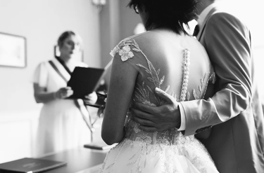 Cérémonie de mariage civil, photo en noir et blanc avec la lecture des vœux par l'officiante.