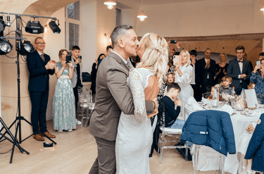 Premier baiser des mariés pendant la réception entourés de leurs invités. au Château de Puxe .