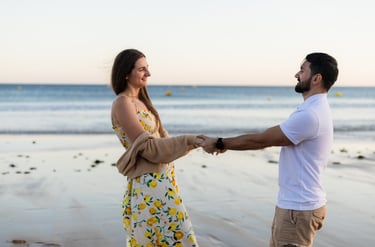 a man and woman holding hands on a beach