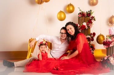 a man and woman sitting on a chair with balloons