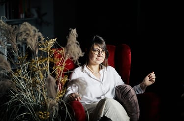 a woman sitting in a chair with a flower in her hand