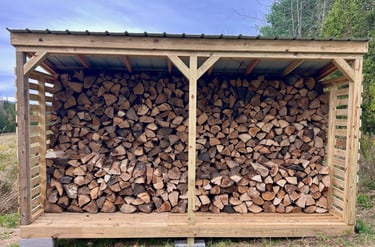 a chord of chopped wood logs stacked on top of each other in a wooden storage shed