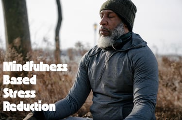 Homme noir assis qui médite avec le programme MBSR, il y a écrit Mindfulness based stress reduction