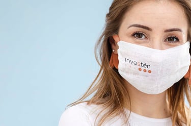 Mujer en primer plano con una mascarilla con el logo de Investén ISCIII