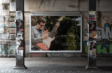 Póster callejero de gran dimensión de un guitarrista anunciando un concierto