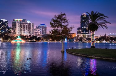 Orlando iluminada refletida no lago ao anoitecer com palmeira decorada