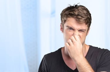 Un joven se tapa la nariz para evitar el mal olor de sus muebles y colchones