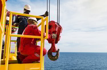 offshore API crane hook being inspected by 2 technicians
