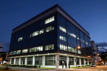 A wide photography shot of a secure, modern Brazilian corporate headquarters at night, with clean architectural lines and professional security presence. Palette of dark navy and steel blue.