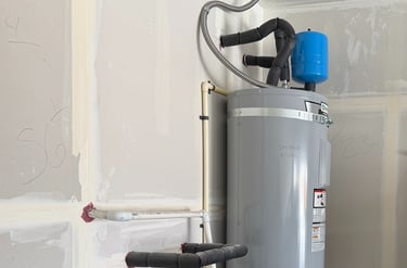 Newly installed electric water heater with blue water pressure tank and insulated pipes in a garage.
