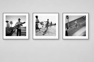 Three framed black-and-white photographs from Martin Osner’s On the Move collection displayed on a gallery wall.