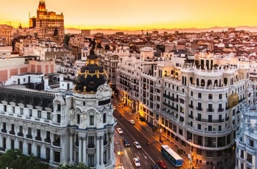 Aerial view of Madrid city skyline at sunset featuring the iconic Metropolis Building on Gran Via.
