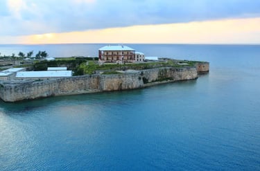 Historical Royal Naval Dockyard fortress overlooking the blue ocean at sunset in Bermuda.