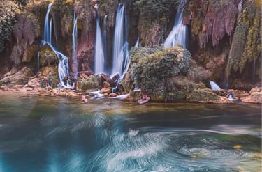 Scenic view of Kravica Waterfall in Bosnia with cascading water and a turquoise lake.