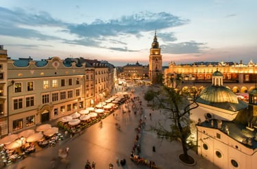Evening view of the historic Main Market Square in Krakow, Poland, with the Cloth Hall and Town Hall Tower.