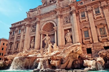 The Trevi Fountain in Rome featuring Baroque architecture, marble statues, and cascading turquoise water.