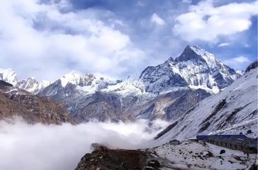 Snow-capped peaks of the Himalayas above a thick layer of clouds at Annapurna Base Camp in Nepal.