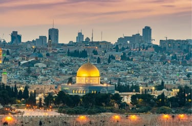 The golden Dome of the Rock stands out against the Jerusalem skyline during a purple sunset.