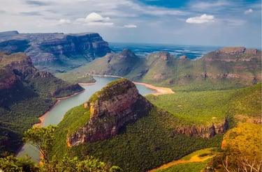 Panoramic view of Blyde River Canyon with lush green mountains and winding river in South Africa.
