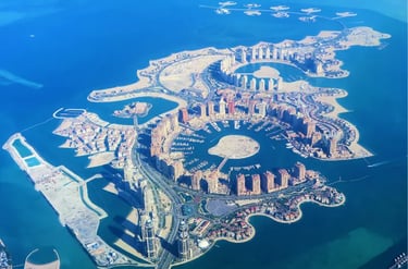 Aerial view of The Pearl-Qatar luxury man-made island featuring Porto Arabia marina and high-rise apartments.