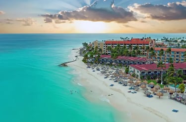 Aerial view of a luxury Caribbean beach resort in Aruba with turquoise water and white sand.