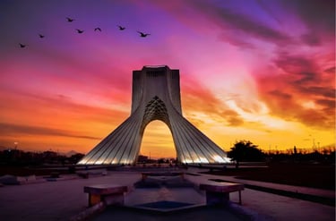 Azadi Tower monument in Tehran, Iran at sunset with a vibrant purple and orange sky and birds flying.