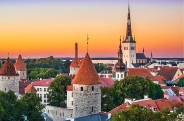 Tallinn Old Town skyline at sunset featuring medieval towers and St. Olaf's Church spire in Estonia.