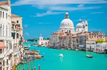The Grand Canal in Venice featuring the Basilica di Santa Maria della Salute and boats on turquoise water.