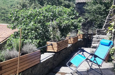 Terrasse inférieure avec transat et vue sur l'entrée du gîte la Petite Corse à Rosis dans l'Hérault