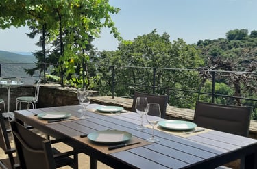 Vue de la terrasse avec table à manger au gîte la Petite Corse à Rosis