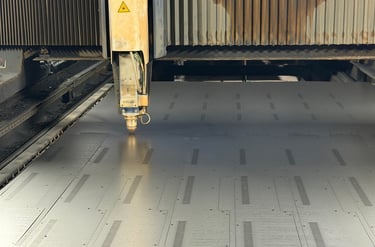 Large-scale fiber laser cutting machine in operation at ClaraTech factory for custom curved J-Curve monitor frames.