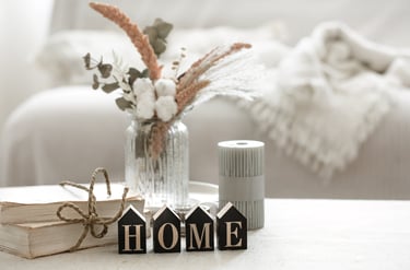 Cozy home vignette with flowers and HOME letters on a table, representing KLEAN WELL’s friendly serv