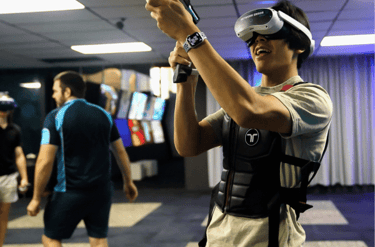 A man in a VR headset and a tacsuit playing a VR game