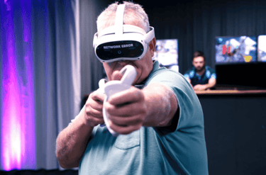 An older man in a blue shirt in a Pico 4 VR headset holding a VR game controller
