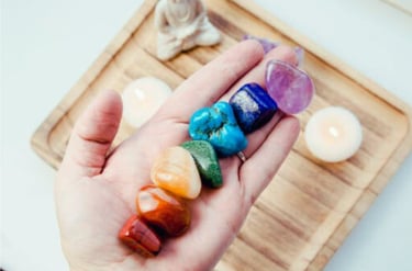 Hand holding chakra stones  a lotus representing spiritual alignment & inner peace.