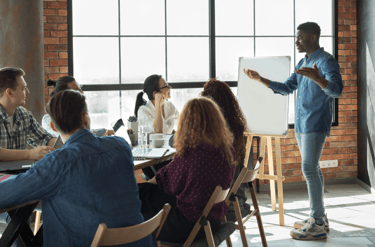 Man presenting to a team in a conference room, representing personal leadership & active engagement.