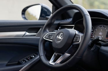 A close-up, high-end photograph of a luxury car steering wheel and leather dashboard, dark navy blue interior with subtle metallic silver accents, soft natural lighting, professional automotive photography style.