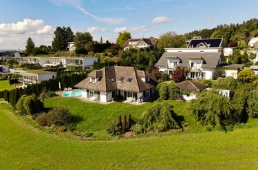 Drohnenaufnahme eines Einfamilienhauses mit Garten, Pool und umliegender Wohngegend