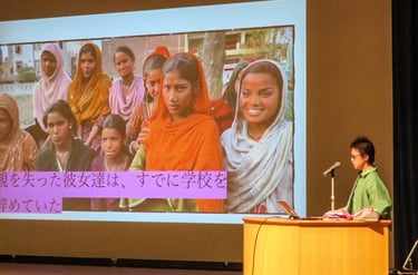 Kayoko giving a lecture on stage.