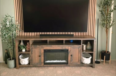 Living room featuring a flat screen TV mounted on a wood slat accent wall above a rustic fireplace media console.