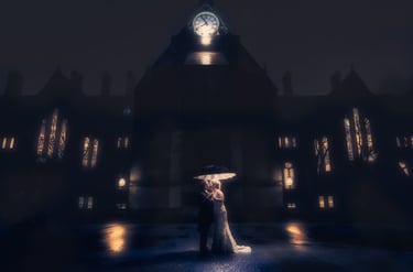 A bride and groom sharing a romantic kiss under an umbrella at night in front of a gothic clock tower.