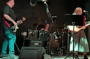 onstage image of band playing with john and rachel