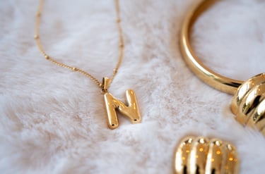 a gold necklace with a gold necklace with a letter m