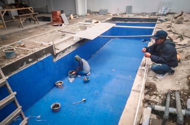 pemasangan keramik roman berwarna biru untuk kolam renang.