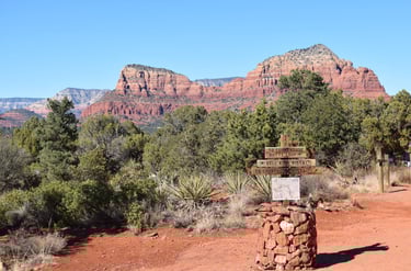 Trail head crossroads wooden marker with red rock Sedona mountain background