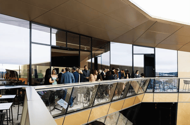 Cocktail d’entreprise en rooftop à Luxembourg pendant une soirée, avec invités en discussion.