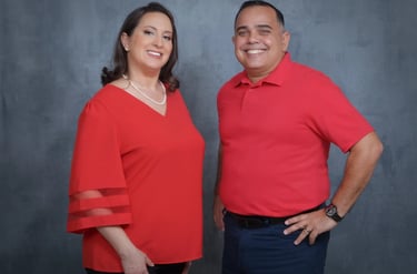 middle aged latin couple wearing red, smiling, rolando and luisa garcia co founders of sunset behavioral health