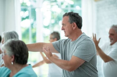 Practicing Tai Chi exercises in a group class - helps in aging well
