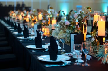 a Annual Dinner with a beautiful table setting with flowers and candles