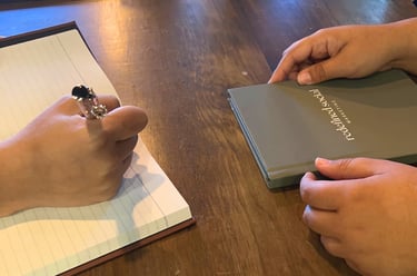 a person holding a book and a notebook